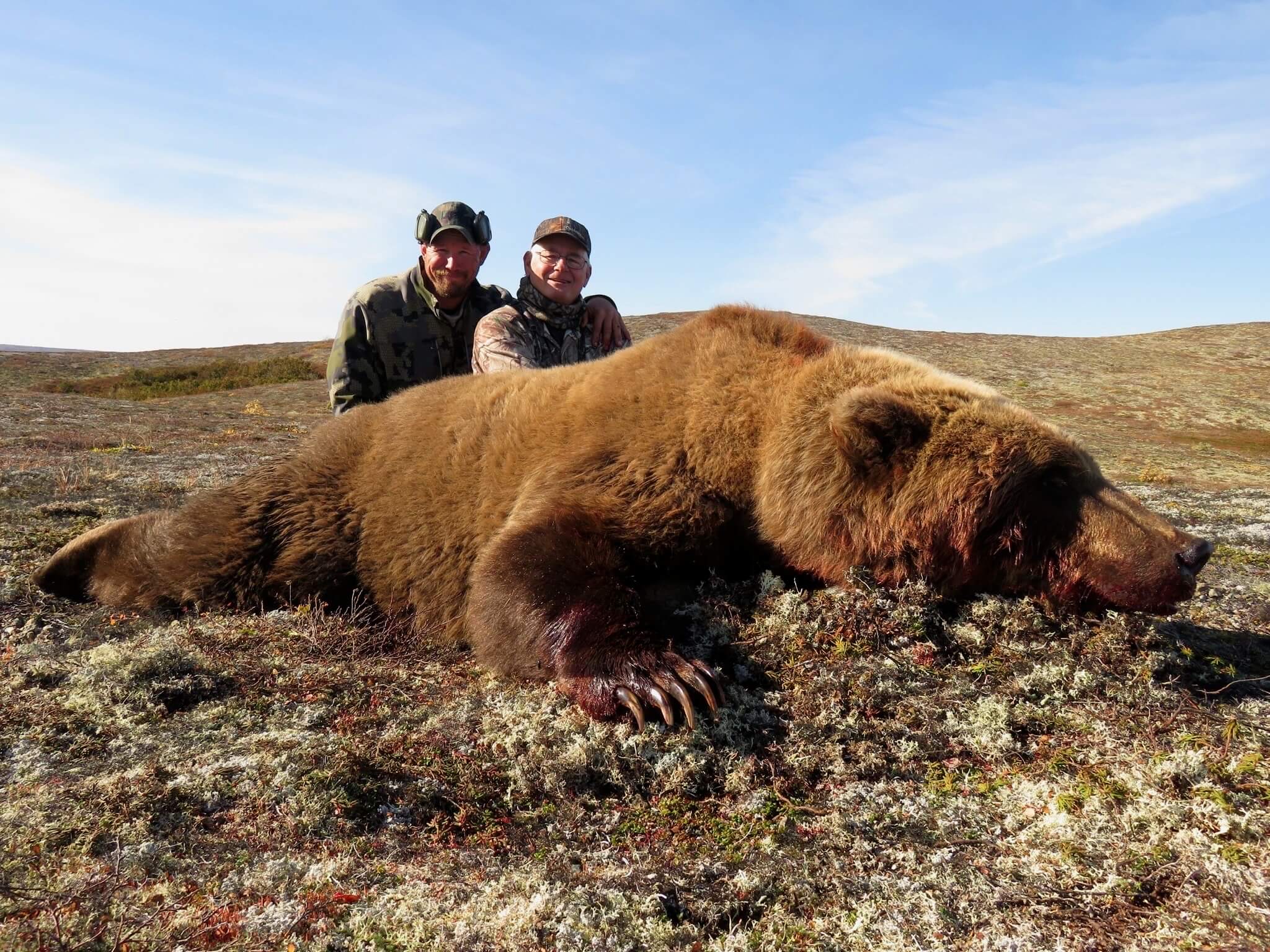 Hunters with a coastal Alaska brown bear